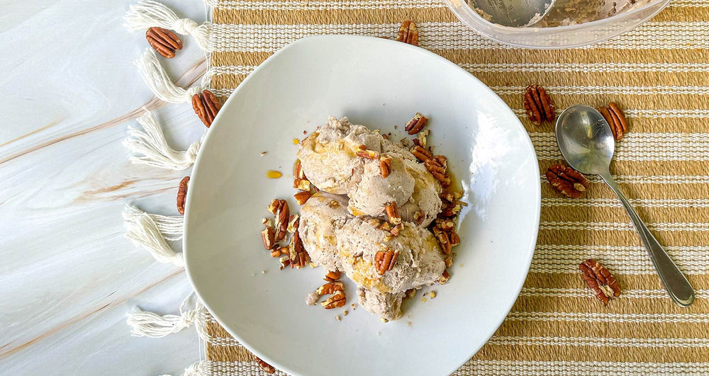A bowl of Pecan butter ice cream garnished with whole pecans 