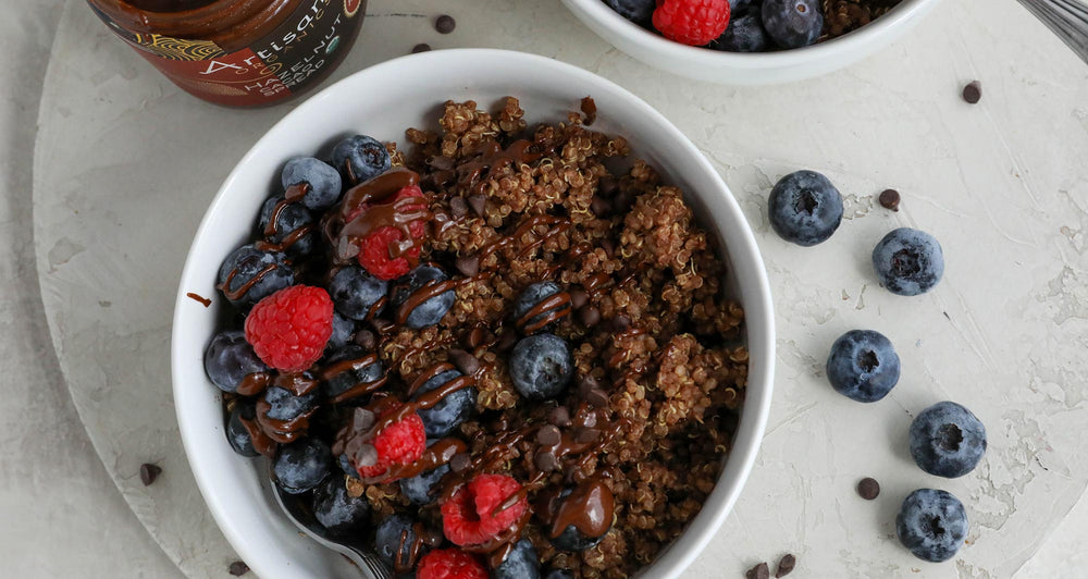 Bowl of chocolate quinoa porridge with fresh berries on top.